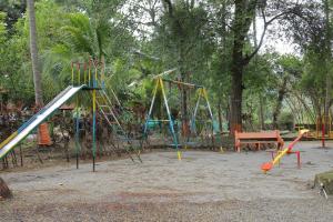 un parque infantil con varios columpios y un tobogán en Kuttralam Resorts, en Kuttālam