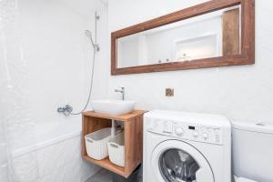 a bathroom with a washing machine and a sink at Smolna 8 by Homeprime in Warsaw