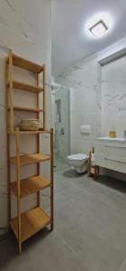 a bathroom with a toilet and a sink and a shelf at Neo Rustic Bucovina in Gura Humorului