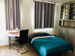 a bedroom with a bed and a table and a desk at Week-end Porte de Clichy in Clichy