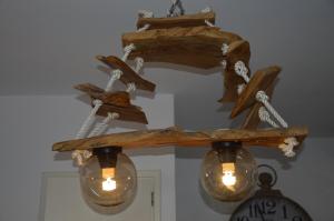 a chandelier with logs and lights and a clock at ThalaSEA - village Antiparos in Antiparos