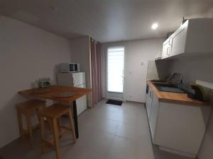 uma cozinha com mesa e cadeiras num quarto em Duplex de 24m2 classé 2 étoiles à 2km d'Aubenas em Aubenas