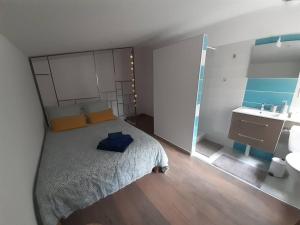um pequeno quarto com uma cama e um lavatório em Duplex de 24m2 classé 2 étoiles à 2km d'Aubenas em Aubenas