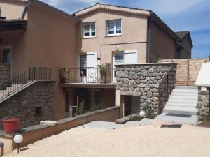 uma casa grande com uma parede de pedra e escadas em Duplex de 24m2 classé 2 étoiles à 2km d'Aubenas em Aubenas