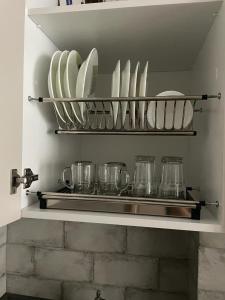 a kitchen shelf with plates and glasses on it at Batumi Sea View in Batumi