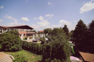 une vue sur un bâtiment avec des arbres et des buissons dans l'établissement C&C Karo Resort, à Bacău