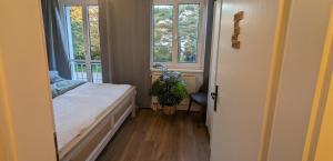 1 dormitorio pequeño con 1 cama y 2 ventanas en Allroom: Moderne Eleganz trifft Vintage-Chic!, en Unterschleißheim