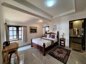 a bedroom with a bed and a table in it at Manigelang Villa in Singaraja