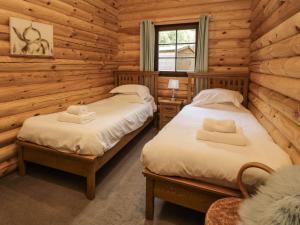 a bedroom with two beds in a log cabin at Welcome Hjem Log Cabin in Morpeth