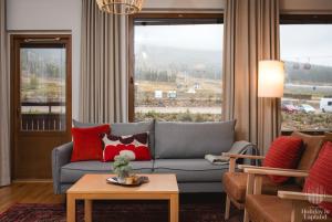uma sala de estar com um sofá e uma grande janela em Holiday in Lapland - Ylläs Gondola apartment, huoneisto 6207 em Ylläsjärvi
