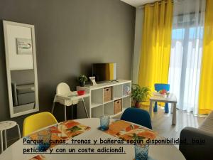 a living room with a table and yellow curtains at Bnbook Medea Apartments in Fuengirola