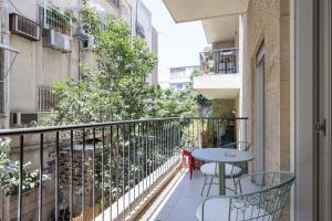 Cet appartement dispose d'un balcon avec une table et des chaises. dans l'établissement TLV2RENT Unique Dizengof Apartment, à Tel Aviv
