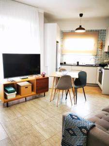 ein Wohnzimmer mit einem TV, einem Tisch und Stühlen in der Unterkunft Apartamento Drago Chico in Icod de los Vinos