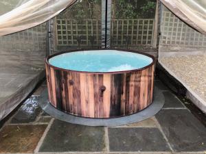 una bañera de madera con agua dentro en Olli's Cottage-Terrace & Jacuzzi en Bristol