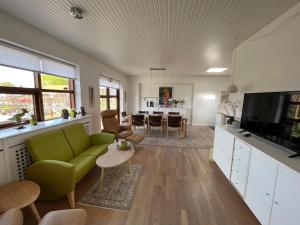 een woonkamer met een groene bank en een tafel bij Hus og have i Herning, 100 kvm ialt in Herning