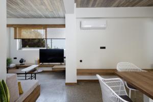 a living room with white walls and a wooden ceiling at New Modern Villa Domus Myrtia with private pool & BBQ, 4km from nearest beach in Marioú