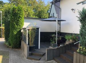 une terrasse avec des escaliers, un parasol et des plantes dans l'établissement Moselidylle und Cityflair - Ferienwohnung Beth, à Coblence