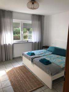 1 dormitorio con 1 cama y 2 ventanas en Moselidylle und Cityflair - Ferienwohnung Beth en Coblenza