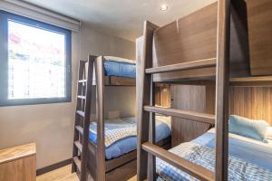 a bunk room with three bunk beds and a window at TODOSIERRANEVADA ZONA BAJA - 2 DORMITORIOS DELUXE REFORMADO - JUNTO A LOS TELECABINAS in Sierra Nevada