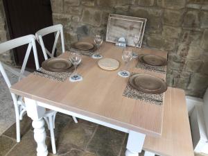 a wooden table with plates and wine glasses on it at Olli's Cottage-Terrace & Jacuzzi in Bristol