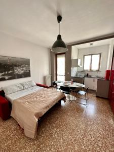 a bedroom with a bed and a table and a kitchen at Casa Voli in Turin
