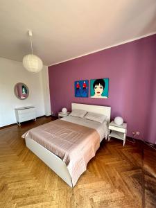 a bedroom with a large bed with purple walls at Casa Voli in Turin