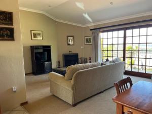 a living room with a couch and a television at Auldstone House in Dullstroom