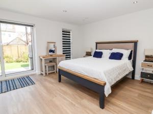 a bedroom with a bed and a large window at The Dunes in Llandudno