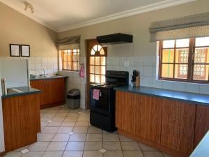 a kitchen with wooden cabinets and a black stove top oven at Auldstone House in Dullstroom