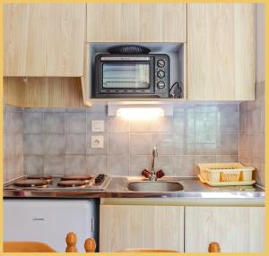 a kitchen with a sink and a microwave at Appartement T2 Téléphérique de NYON Morzine in Morzine