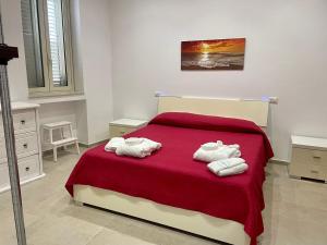 una camera da letto con un letto e asciugamani di A 2 passi dal mare Torre Faro LA PUNTA SeaHouse a Torre di Faro