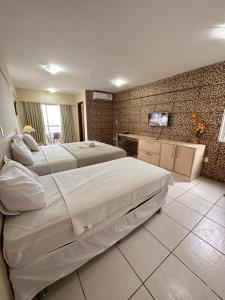 1 dormitorio grande con 2 camas y barra en Terrazzo Ponta Negra Flat, en Natal