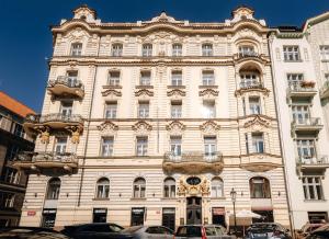 een groot gebouw met auto's ervoor geparkeerd bij Prague Castle King's Chic in Praag