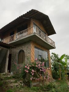 uma casa com uma varanda em cima em Homstay Gốc Vải em Dan Mey