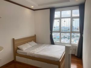 a bedroom with a bed and a large window at Spacious Apartment with 3-bedroom in District 7 in Ho Chi Minh City