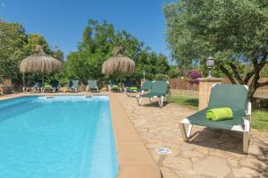 een zwembad met stoelen en parasols in een tuin bij Finca Pili Mallorca in Felanitx