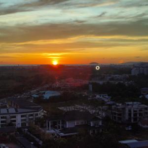 a sunset over a city with the sun setting at ITCC Manhattan Suites by Pleasant Amenities in Donggongon