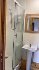 a bathroom with a glass shower and a sink at The Berkeley in Peopleton