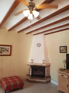 a living room with a fireplace and a ceiling fan at Villa Limon Playa Flamenca in Alicante