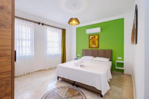 a bedroom with two beds and a green wall at Mel Town in Antalya