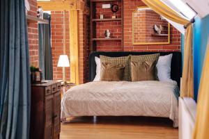 een slaapkamer met een bed en een bakstenen muur bij Prague Castle King's Chic in Praag