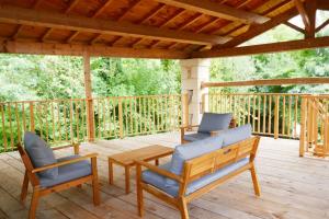2 chaises et une table sur une terrasse en bois dans l'établissement Les Plaisirs dIrleau, à Le Vanneau