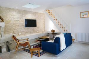 - un salon avec un canapé bleu et un escalier dans l'établissement Les Plaisirs dIrleau, à Le Vanneau
