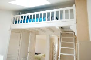 a bunk bed with a ladder in a room at Les Plaisirs dIrleau in Le Vanneau
