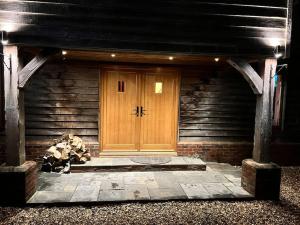 a wooden front door of a wooden house at 10 sleeper beautiful house with 8 seat hot tub! in Durley