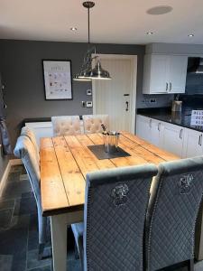 a kitchen with a wooden table with chairs around it at 10 sleeper beautiful house with 8 seat hot tub! in Durley