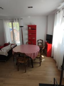 ein Esszimmer mit einem Tisch und Stühlen sowie einer roten Kommode in der Unterkunft Charmante maison in Chaville