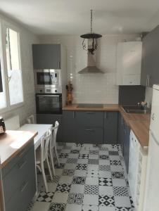eine Küche mit schwarzweißem Fliesenboden in der Unterkunft Charmante maison in Chaville