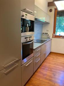 a kitchen with stainless steel appliances and a wooden floor at Aquincum Dunaparti Apartman in Budapest