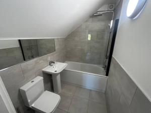 a bathroom with a toilet and a sink and a bath tub at Beautiful apartment in Frampton in Bristol